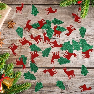 Christmas confetti with red reindeer and green glitter trees on rustic wood background