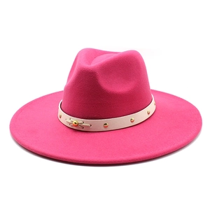 Close-up of rose red wool fedora hat with studded cream leather band and bow detail