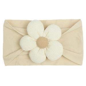 Detail of baby elastic nylon headband with beige corduroy flower and soft fabric texture