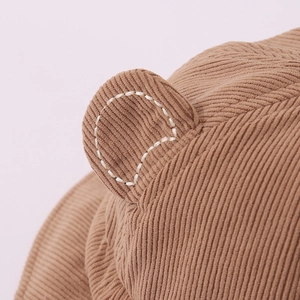 Detailaufnahme des braunen Cord-Babyhutes mit 3D-Ohren und weißen Kontrastnähten