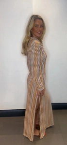 Detail of multi-color crochet knit dress featuring geometric squares and a high side slit