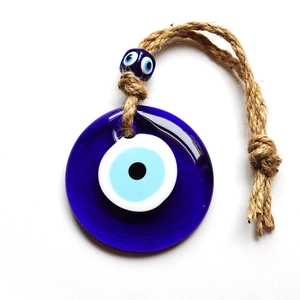 Close-up of Turkish blue glass Evil Eye pendant with rustic hemp rope and mini glass bead