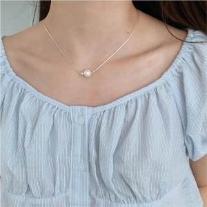 Elegant 925 sterling silver necklace with single white pearl pendant on collarbone