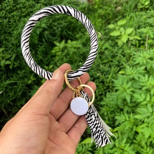 Zebra print O-shaped PU leather keychain bracelet with gold ring and tassel detail