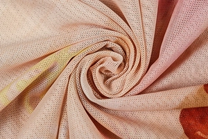 Gros plan sur tissu en maille beige avec imprimé dégradé rouge et texture respirante