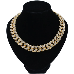 Golden 20mm Cuban link chain necklace with sparkling rhinestones on a black mannequin