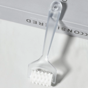 Close-up of manual roller massager with textured rolling balls and frosted handle