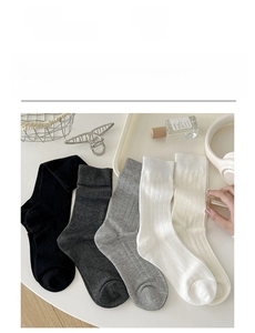 Detailed view of five pairs of rib-knit mid-calf socks in neutral grey and white tones