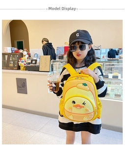 Toddler girl wearing a lightweight yellow cartoon duck backpack in a cafe setting
