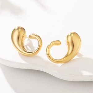 Elegant gold fluid C-shaped stainless steel earrings on white wavy background