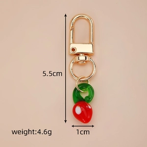 Detail showing red strawberry glass keychain dimensions of 5.5cm length and 4.6g weight