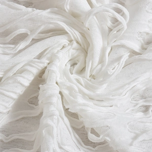 Macro detail of white pleated fabric with mesh texture and hanging fringe tassels