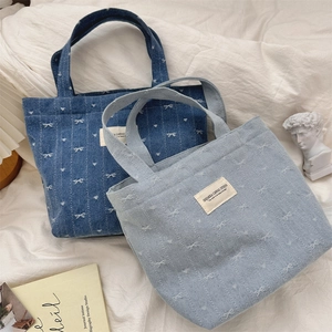 Détails des sacs fourre-tout en toile denim avec broderie nœud blanc et textures