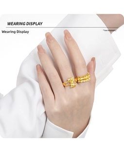 Close-up of elegant gold bow ring and textured band worn on hand for a minimalist look