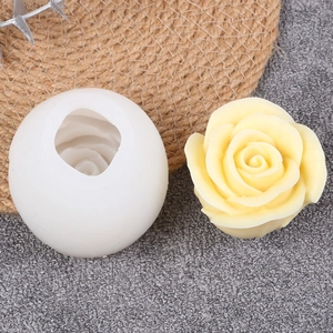 Macro shot of 3D rose silicone mold with finished floral candle on a rustic stone background