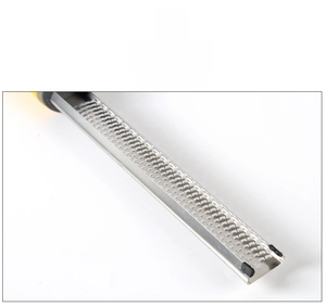 Close-up of stainless steel cheese grater with micro blades and black non-slip rubber foot