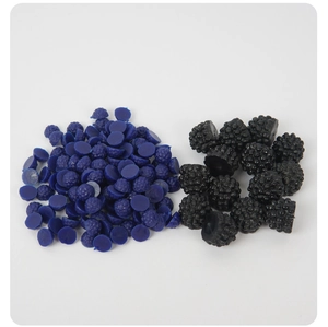 Vista macro de mini bayas de resina azules y negras para manualidades DIY y decoración