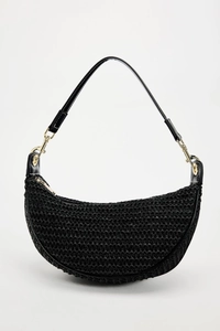 Detail of black woven crescent bag featuring golden metallic hardware and leather strap
