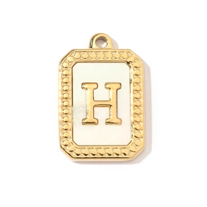 Close-up of golden stainless steel rectangular pendant with white shell and letter H