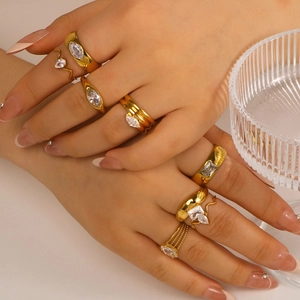 Stapelbare goldene Edelstahlringe mit Zirkonia-Steinen an der Hand eines Models