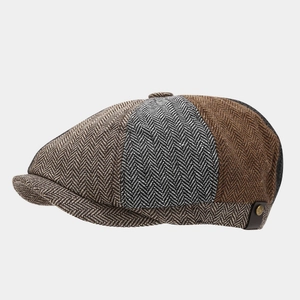 Close-up of herringbone newsboy cap with multi-color patchwork and leather buckle