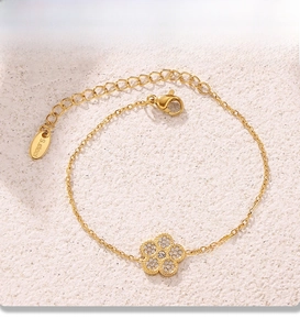 Detail of PVD gold plated bracelet with clover charm and adjustable lobster clasp