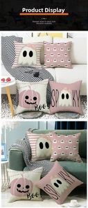 Detail of pink Halloween pillow covers with ghost patterns and Spooky text on a sofa