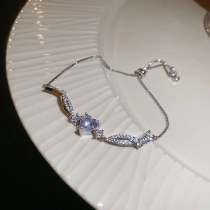 Macro view of adjustable silver bracelet with light blue heart zircon and pavé crystals