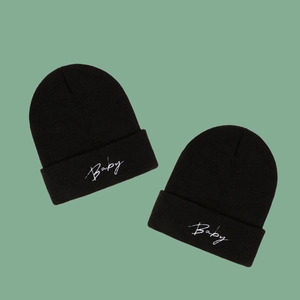 Two black knitted beanie hats with white Baby embroidery on soft ribbed folded cuff