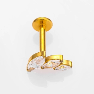 Gros plan d'un labret en titane G23 doré avec trois zircons marquise en forme de feuille