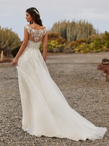 Elegant ivory lace wedding dress with open back floral embroidery and long tulle train