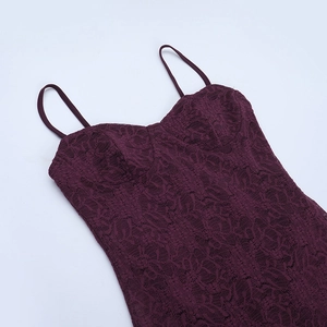 Macro detail of dark purple lace fabric with intricate floral patterns on a backless dress