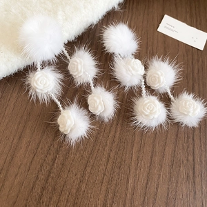 Detail of white pompom earrings with mink fur, crystal beads and rose flowers for winter