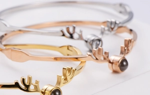 Tre braccialetti con corna di cervo in finiture oro, oro rosa e argento lucido