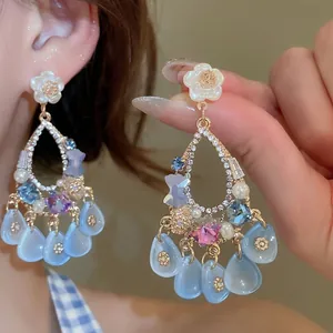 Elegant floral drop earrings with pearls and crystals shown on model in warm studio lighting