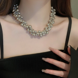 Silver bead choker necklace with geometric bubble design on female model in black top