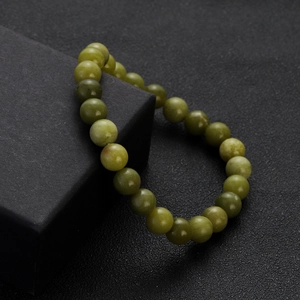 Close-up of natural green jadeite beads bracelet on a black textured presentation box