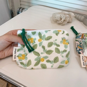 Close-up of green floral cotton coin purse with zipper and simple wish label