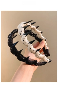 Close-up of fabric hairbands with polka dot patterns and stylish shiny black spikes