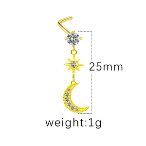 Détail d'un piercing de nez doré avec pendentifs lune et étoile et zircons clairs