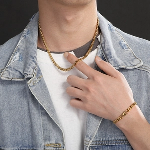Golden titanium steel Cuban chain necklace and bracelet set worn by male model