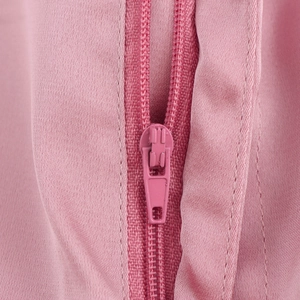 Gros plan sur la fermeture éclair rose en nylon et les dents pour l'ensemble plissé femme