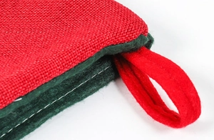 Close-up of linen Christmas stocking featuring red and green fabric with white stitching