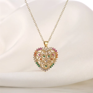 Detailed close-up of a golden heart pendant featuring intricate hollow tree and colorful gems