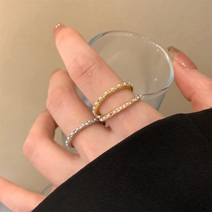 Close-up of 14K gold plated pearl and zircon rings worn on female fingers