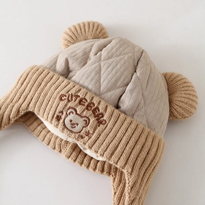 Winter knitted earflap hat for toddlers featuring cute bear design and quilted details