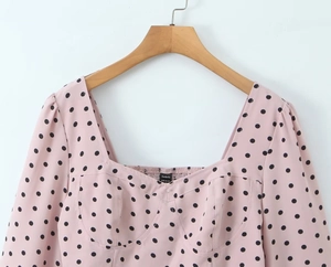 Détail du haut rose à pois avec encolure carrée, manches bouffantes et coutures