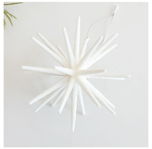 Macro detail of a white exploding star Christmas ornament with silver glitter and hanging cord