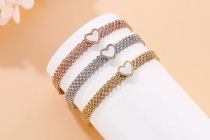 Macro view of multi-layer heart bracelets in gold, silver, and rose gold finishes