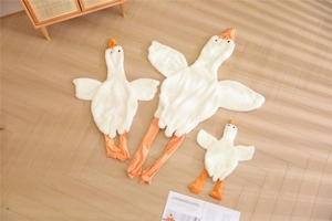 Unstuffed white goose plush toy shells in three different sizes on floor